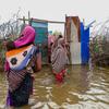 在索马里乔哈尔市，妇女们在洪水中涉水。