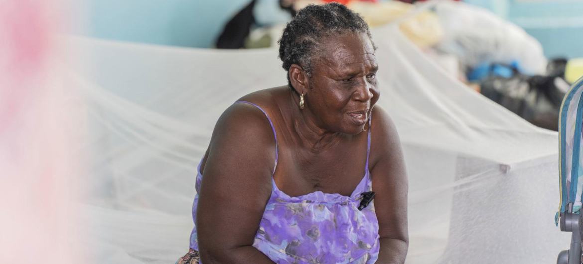 Sonia sits on a bed at a shelter for people who lost their homes due to Hurricane Melissa.