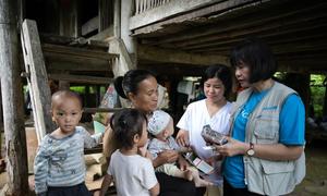 Un miembro del personal de UNICEF entrega alimentos listos para consumir a una familia en Tuyên Quang, Vietnam.