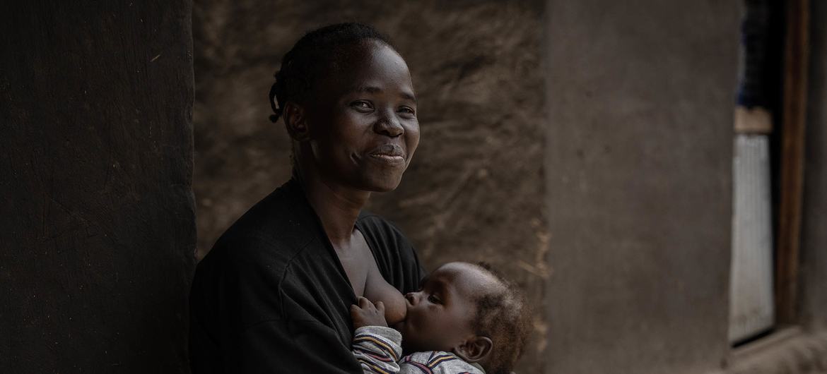 在乌干达，30 岁的克里斯汀正在给孩子哺乳。
