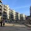 يتفقد السكان الأضرار التي لحقت بمشاريع الإسكان غير المكتملة في حلب، سوريا، بعد النزوح والقتال. ويظهر مشروعا 1070 ورياضة دماراً واسع النطاق.