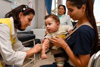 दक्षिण सीरिया के एक स्वास्थ्य केंद्र में, आठ महीने के बच्चे को पोलियो और ख़सरे के टीके लगाए जा रहे हैं.