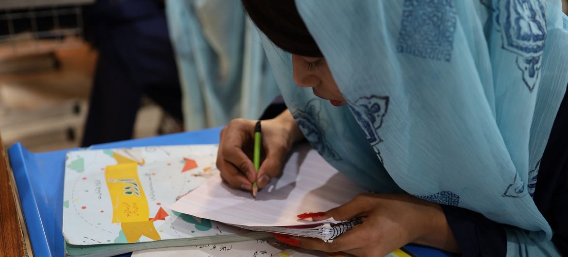 UNESCO تعلیمی پروگرام کے دوران ملتان کے ایک ٹرانس جینڈر سکول میں ایک طالب علم ایک نوٹ بک میں لکھ رہا ہے۔