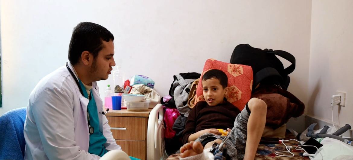 El doctor Abdelrahaman de Gaza habla con un niño herido en el Hospital Shuhadaaa Elaqsa.