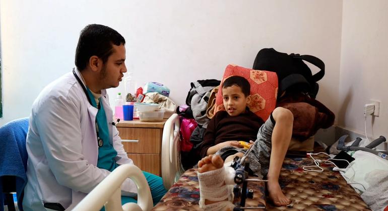 الطبيب عبد الرحمن الطيب يتحدث إلى طفل مصاب في مستشفى شهداء الأقصى في مدينة دير البلح في غزة.