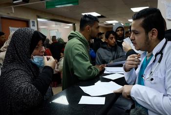 Un médecin à Gaza parle à un patient.