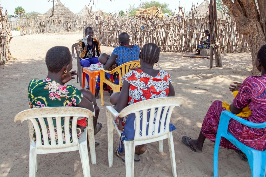 Mfanyakazi wa Afya wa Bomi anayeungwa mkono na UNICEF Awan Agaan anashauriana na wakazi wa eneo hilo, akiwemo Deborah Yar na binti yake, katika kijiji kimoja huko Sudan Kusini.