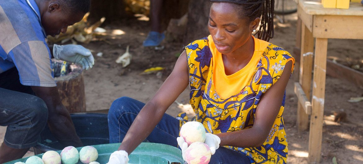 Mulher vende sabonetes caseiros em Gana como parte de um projeto da ONU para melhorar os meios de subsistência.