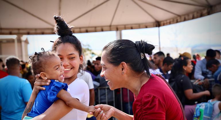 Mujeres venezolanas acurrucan a un bebé mientras esperan para realizar los trámites migratorios. Foto: OIM/Gema Cortes