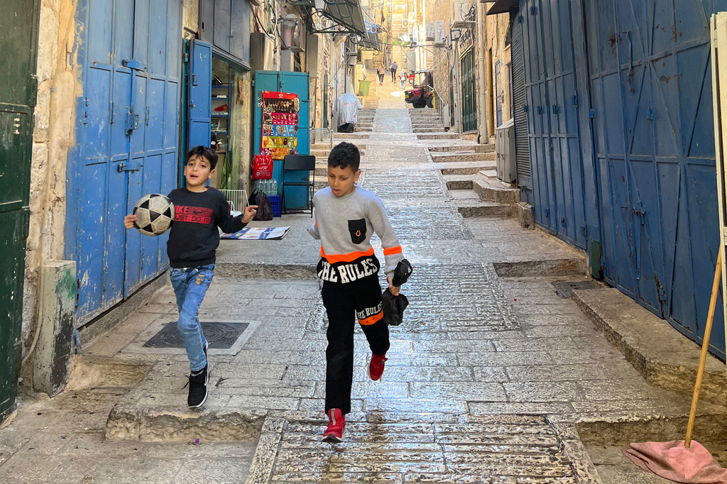 Deux jeunes garçons courent dans les rues de Jérusalem.