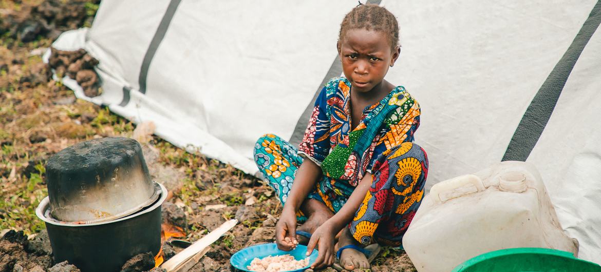 A young child eats food in a camp for displaced people in North Kivu province following fighting in eastern Democratic Republic of the Congo.