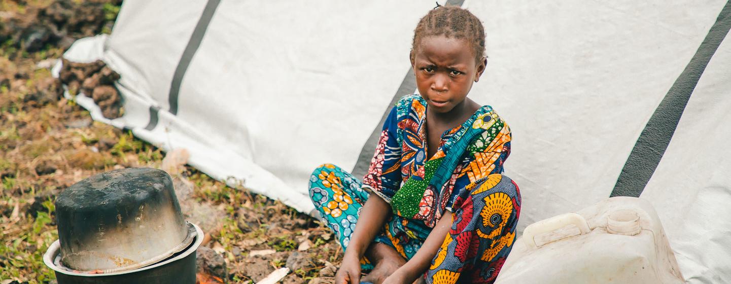 पूर्वी काँगो लोकतांत्रिक गणराज्य के नॉर्थ किवू में विस्थापितों के लिए बनाए गए एक शिविर में एक बच्ची भोजन कर रही है.