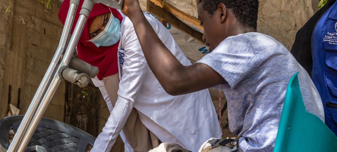 طبيبة من منظمة الهجرة الدولية تفحص أحد المهاجرين في اليمن