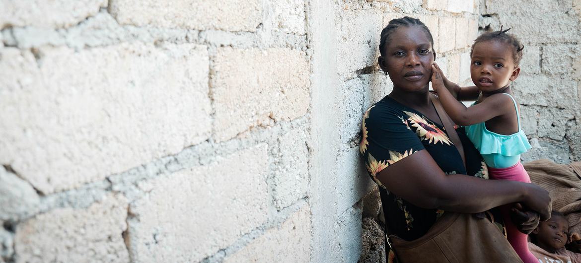 Une mère à Léogâne, en Haïti, tient son enfant dans ses bras dans un site de fortune pour personnes récemment déplacées.