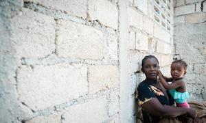 Uma mãe em Léogâne, Haiti, segura o seu filho num local improvisado para pessoas recentemente deslocadas
