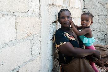 海地一位母亲在为流离失所者临时搭建的安置点抱着自己的孩子。