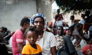 A mother sits with her child at a site for displaced people in Haiti.