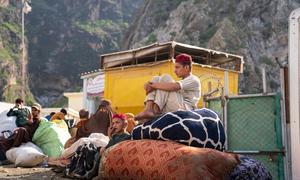 Two brothers wait at the Torkham border between Pakistan and Afghanistan with their family, after returning from Pakistan.