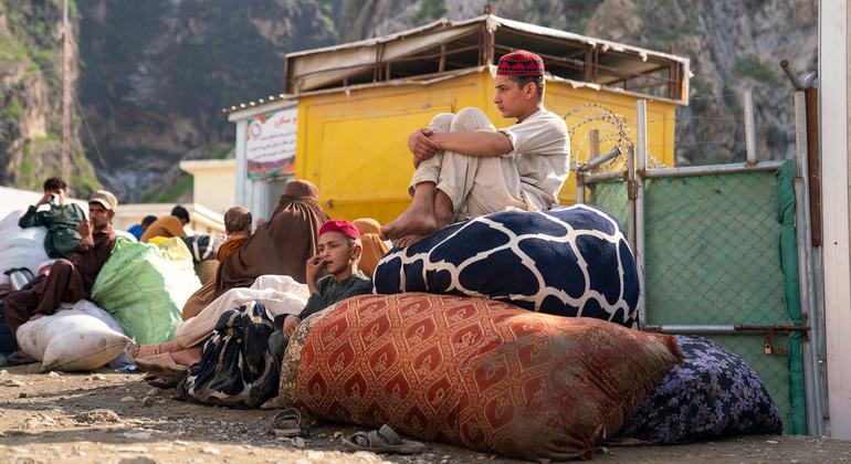 Two brothers wait at the Torkham border between Pakistan and Afghanistan with their family, after returning from Pakistan.
