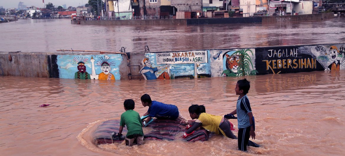 印度尼西亚东雅加达，孩子们在慈利翁河溢出的水中玩耍。