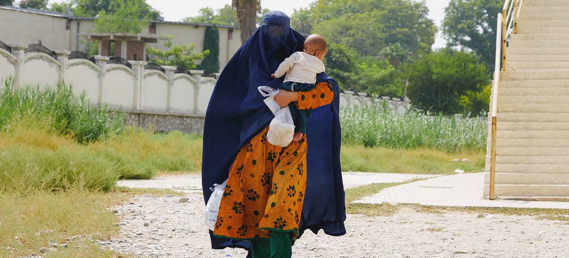 Uma mãe recebe a última ajuda alimentar do PMA para sua família em Jalalabad, Afeganistão