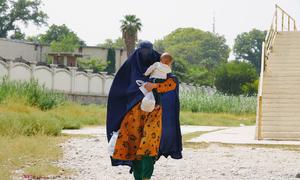 A woman walks with her child in her arms in Jalalabad, Afghanistan.