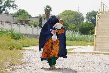 在阿富汗贾拉拉巴德，一名母亲最后一次从粮食计划署领取了家人的口粮。