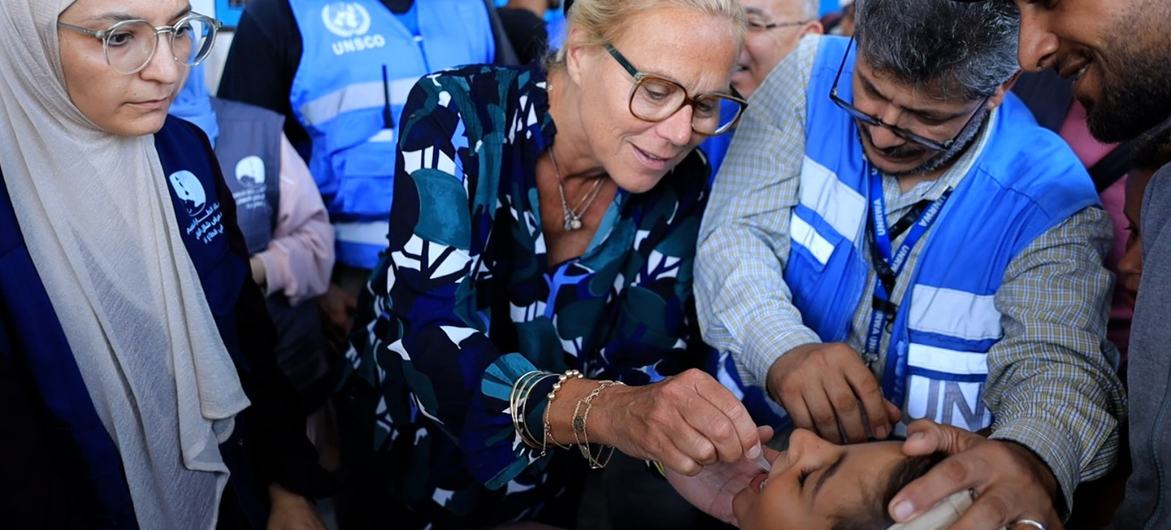 Sigrid Kaag, Senior Coordinator for Humanitarian Affairs and Reconstruction in Gaza, administers a dose of the polio vaccine to a child in Gaza.