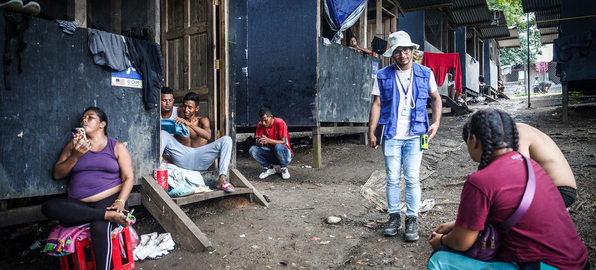 Un trabajado de la OIM habla con migrantes venezolanos en la estación migratoria de Lajas Blancas en Darién.