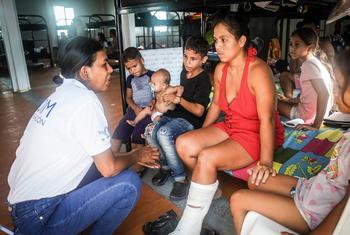 Etzaida Rios, oficial de la OIM, habla con Zuleybis, una migrante que se fracturó la pierna al momento de cruzar el Darién. 