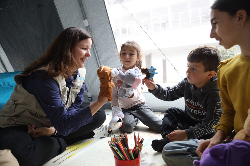 A UNICEF Representative interacts with refugee children at a children's corner in Goris, Armenia.