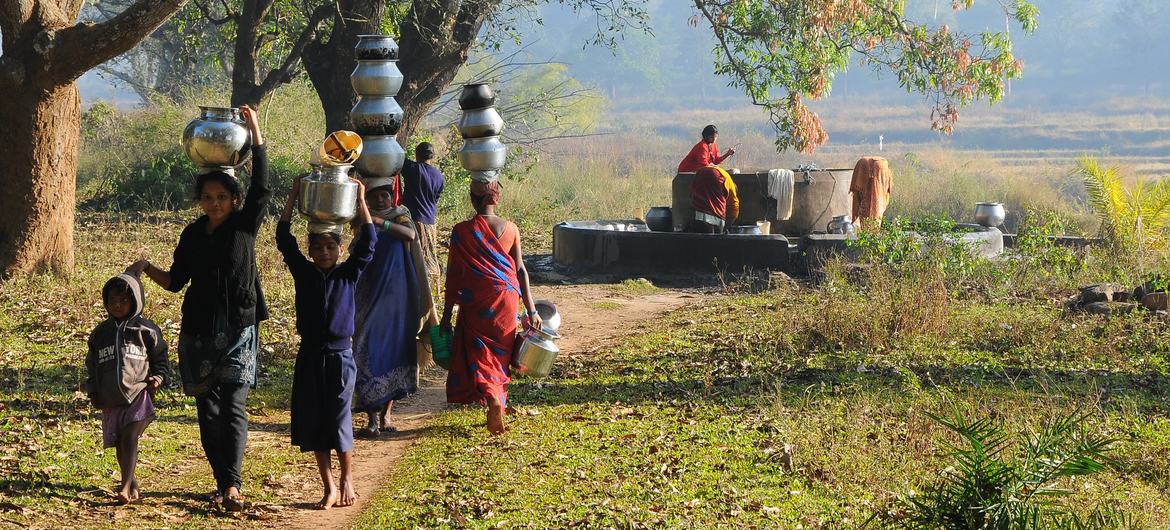 Women and children in a village fetch water from a well. Such chores keep children from attending classes and leaves women unable to engage in formal sectors. Women and children in a village fetch water from a well. Such chores keep children from attending classes and leaves women unable to engage in formal sectors.