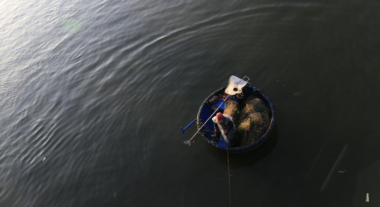 一名渔民在越南海岸附近的小木筏上作业。全球范围内，数千万人的生计极为不稳定，且往往无法获得社会保障。
