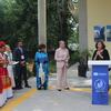 Una mujer habla desde un podio con el logotipo de la UNESCO durante un evento sobre racismo y discriminación en México, 2022, con otros asistentes de pie cerca.