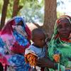 在苏丹南达尔富尔的一个流离失所者营地，妇女排队等待世界粮食计划署发放现金援助。