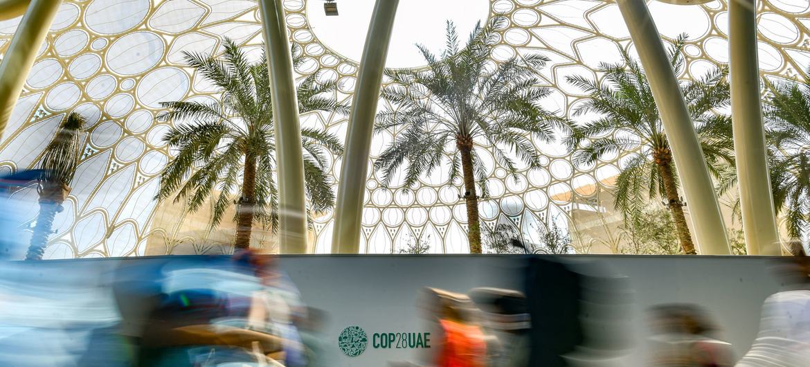 Los asistentes corren de un lugar a otro durante la Conferencia de las Naciones Unidas sobre el Cambio Climático COP28 en Expo City, en la ciudad de Dubai, en Emiratos Árabes Unidos.