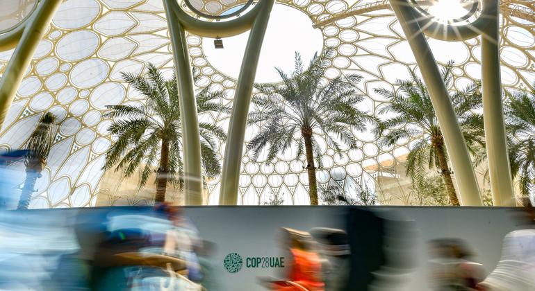 Attendees rush between venues during the UN Climate Change Conference COP28 at Expo City, in Dubai, United Arab Emirates.