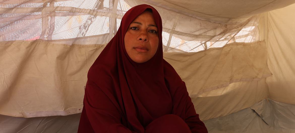 Sabah sits inside a temporary shelter after spending weeks without a safe place to sleep. 