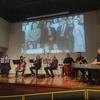 Des musiciens se produisent sur scène lors de la projection du documentaire « The Rescue » au Mexique, tandis qu'une grande photo en noir et blanc est projetée sur l'écran derrière eux.