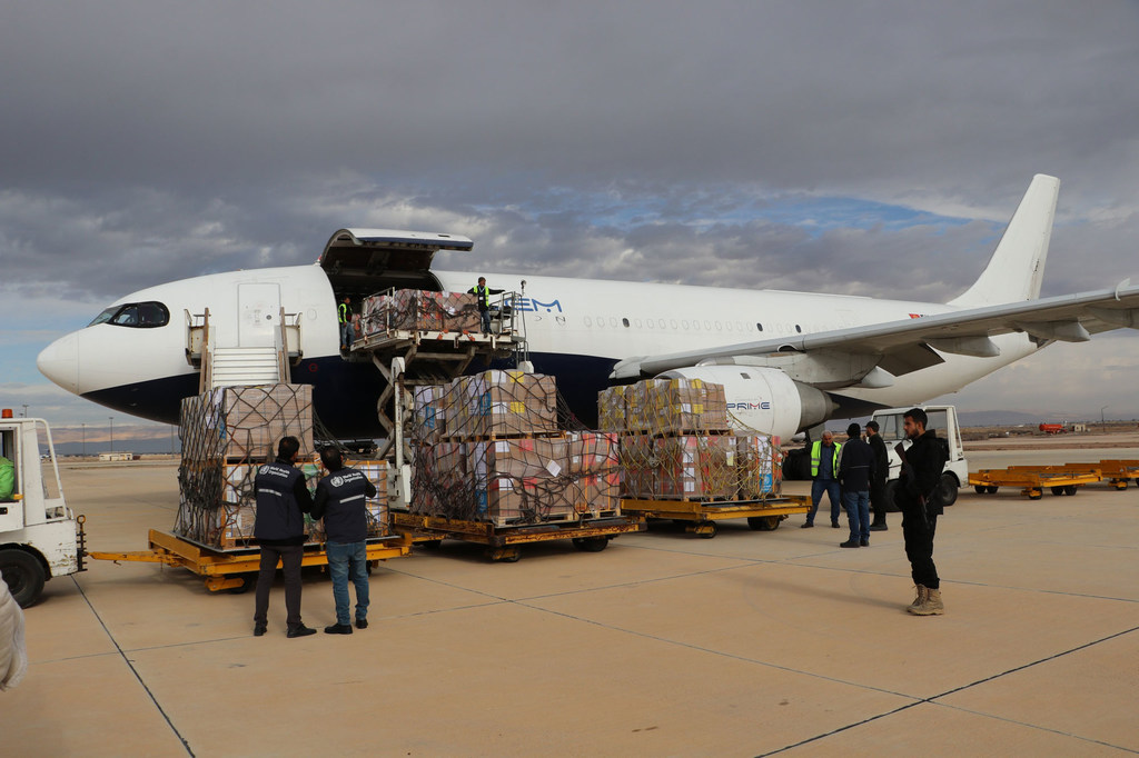 Personal de la OMS descarga palés de suministros médicos de emergencia de un avión fletado en el aeropuerto internacional de Damasco, en Siria.