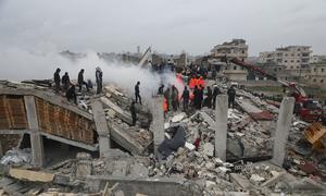 Rescue workers look for survivors in a building  in Samada, Syria destroyed by the February 6 earthquake.