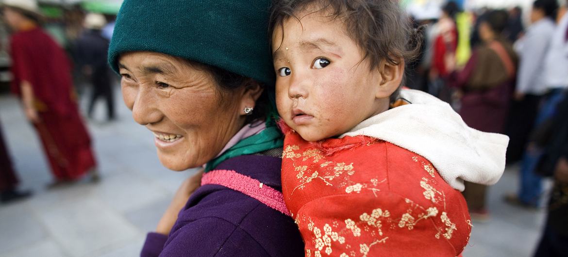 A woman carries a child in Barkhor, in the Tibet Autonomous Region. (file)