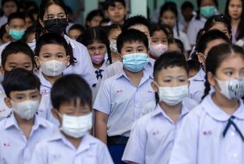 由于空气污染水平飙升，曼谷一所小学的学生在晨练时戴上了口罩。