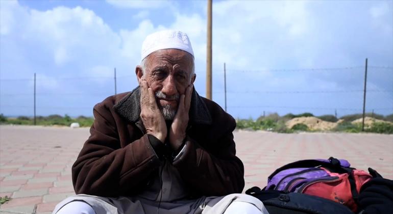 عبد الله قرموط يمسح دموعه خلال مقابلة مع أخبار الأمم المتحدة خلال رحلته من شمال غزة إلى الجنوب.