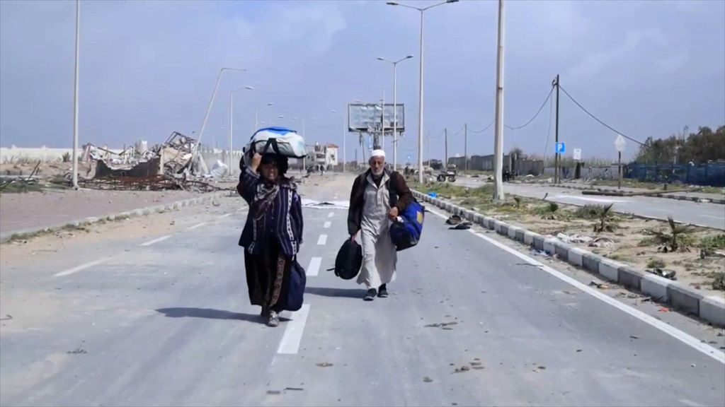 Abdullah y Aisha Qarmout caminando por la calle al-Rachid en su trayecto desde el norte de Gaza hacia el sur.