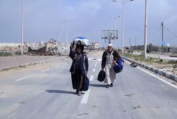 Abdullah y Aisha Qarmout caminando por la calle al-Rachid en su trayecto desde el norte de Gaza hacia el sur.