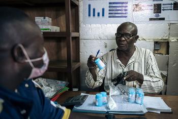 Un distributeur communautaire polyvalent délivre son traitement à un patient au Poste de distribution des ARV pour patients stable (PODI) de la commune de Lingwala à Kinshasa, RDC.