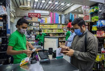 پاکستان کے ساحلی شہر کراچی میں لوگ ایک دوکان پر خریداری کرتے ہوئے (فائل فوٹو)۔