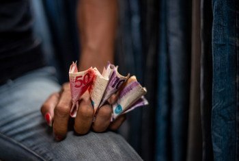 菲律宾马尼拉的一位小贩手里攥着当地货币。