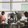 Um grupo de pessoas trabalha em seus computadores em um escritório